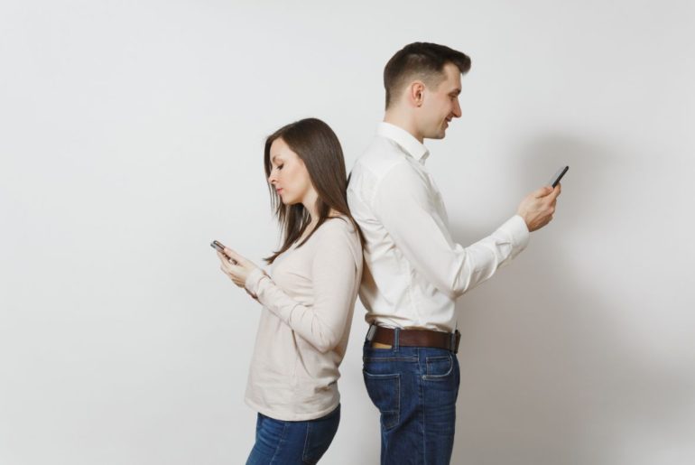 Man and woman texting facing away