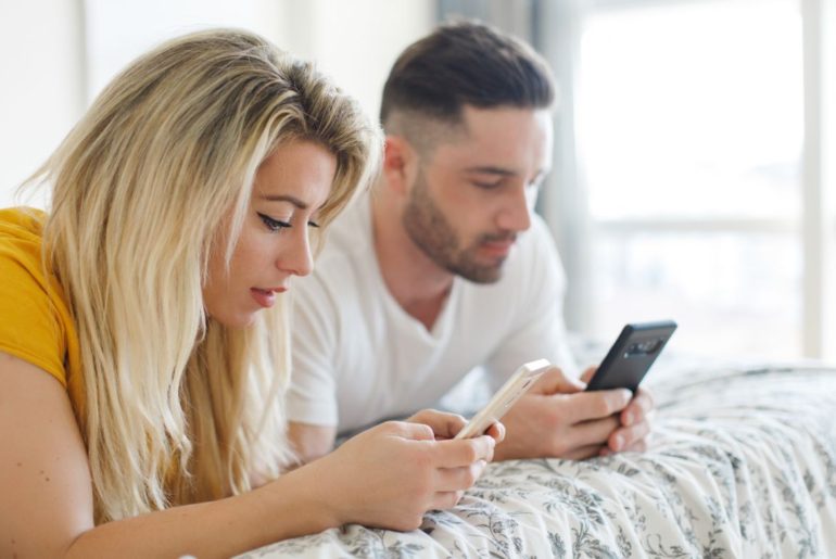 Man and woman texting next to each other