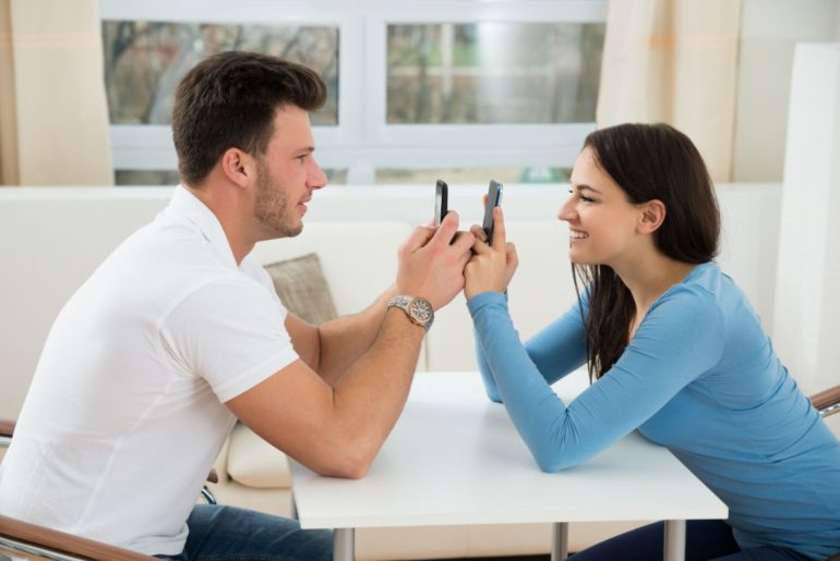 Man and woman with phones facing each other