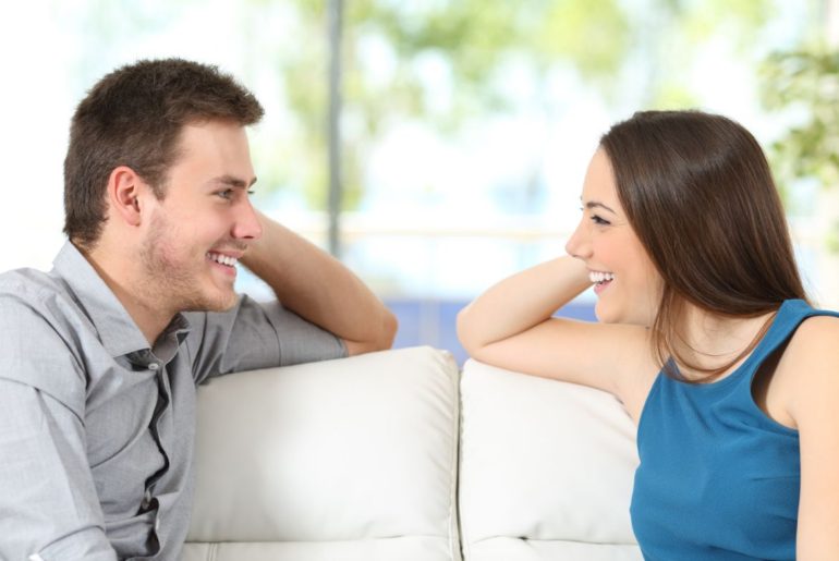 Woman and man smiling looking at each other