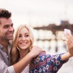 Woman taking selfie with man